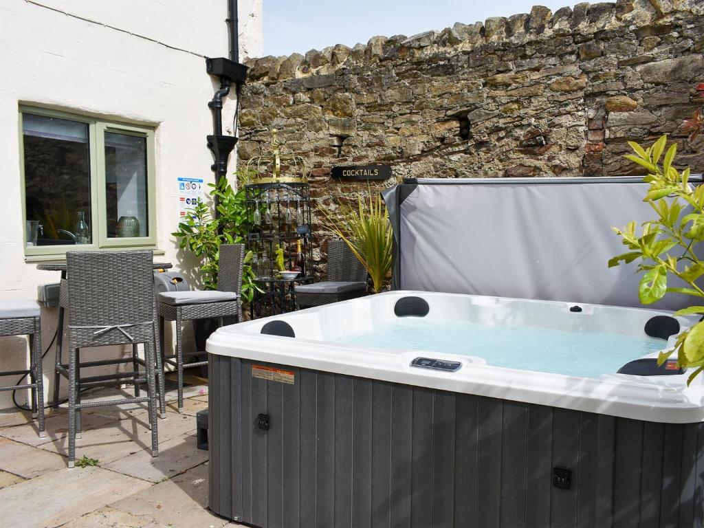 a hot tub on a patio with a table and chairs at Ellerton House in Richmond