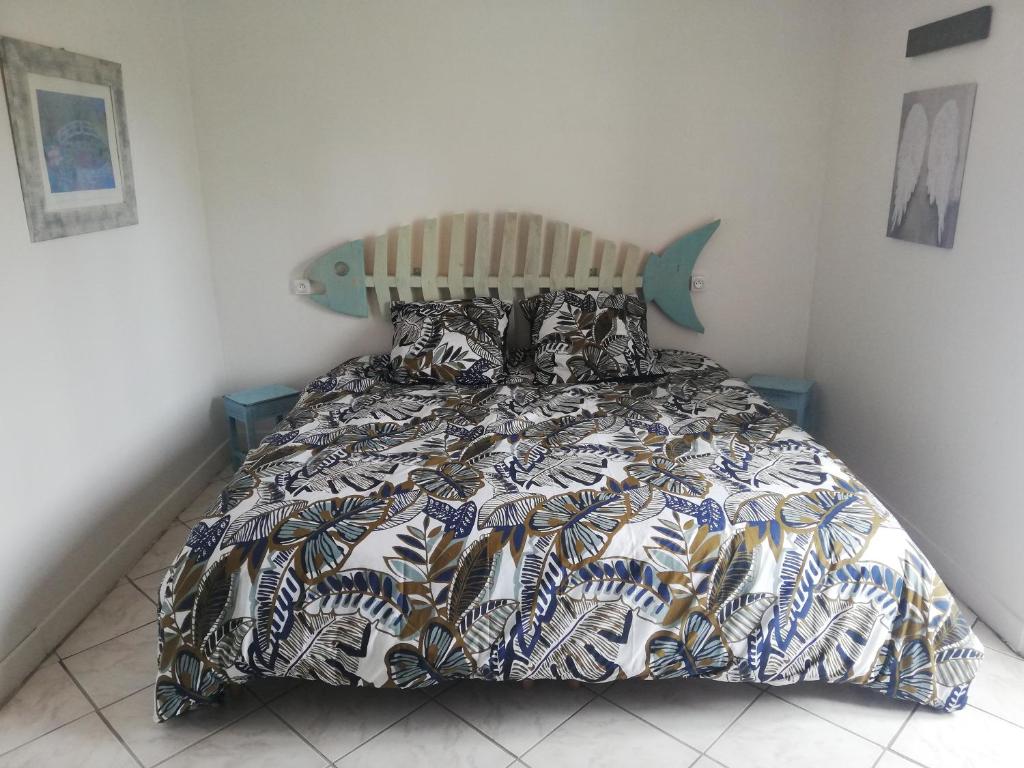 a bedroom with a bed with a comforter and pillows at Le gîte des Mégalithes in Le Bernard