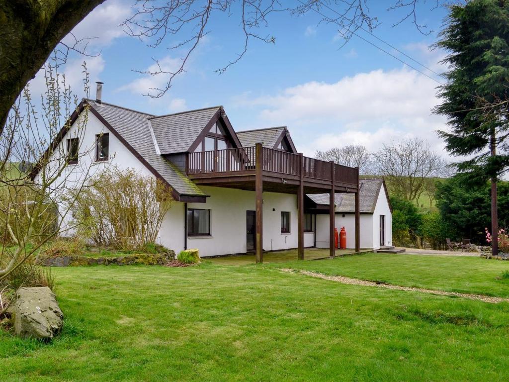 uma casa com um deque no topo de um quintal em Chestnut Lodge em Portpatrick