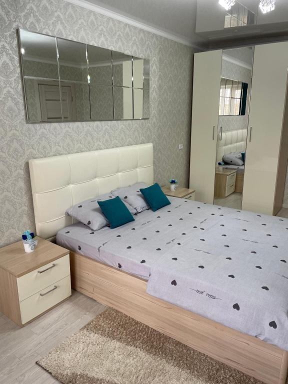 ein Schlafzimmer mit einem großen Bett und einem Spiegel in der Unterkunft VIP квартира центр in Oral