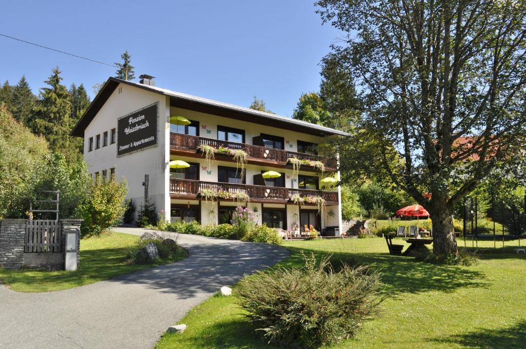 a large building with a park in front of it at Pension & Apartments Weissbriach in Weissbriach