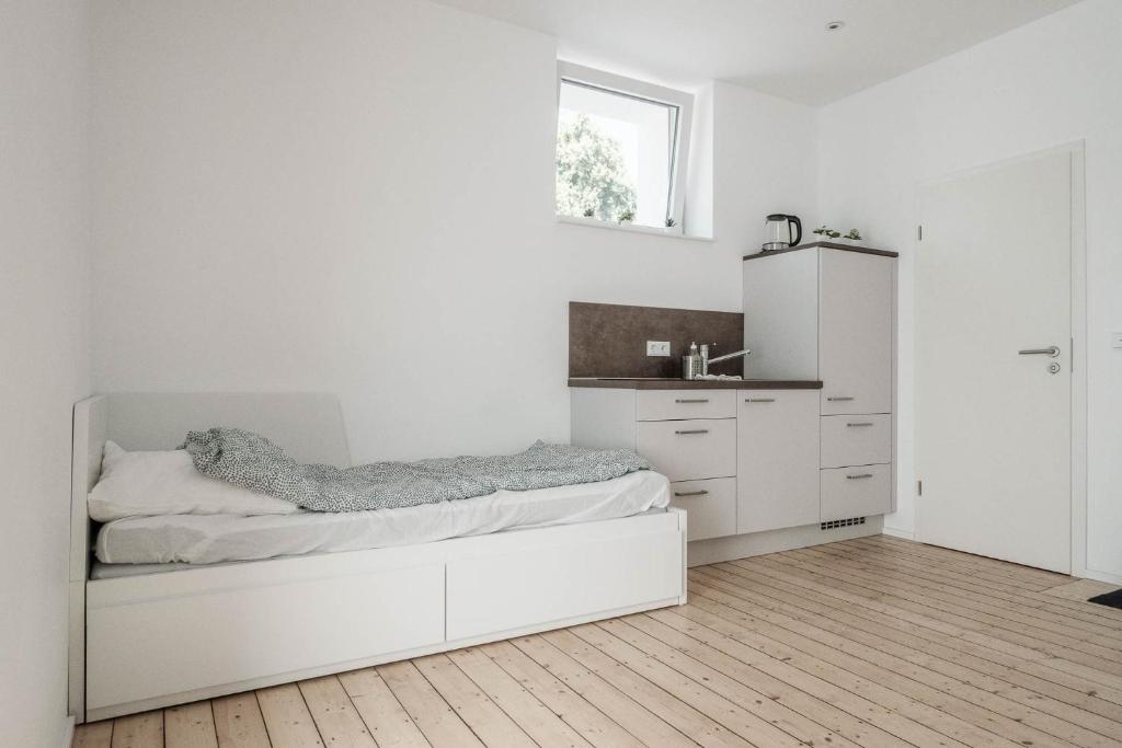 a white bedroom with a bed and a sink at Kinderklinik 600m zum Bahnhof 2A in Siegen