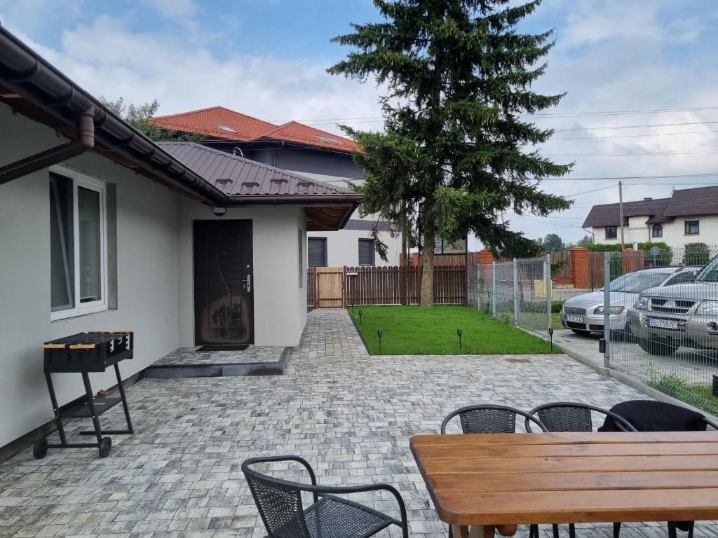 patio ze stołem i krzesłami przed domem w obiekcie Villa Akacjowa w mieście Turbia