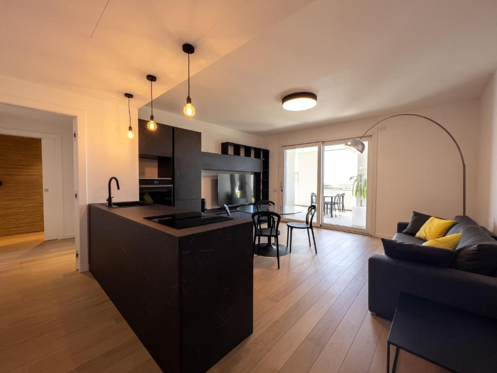 a kitchen and living room with a couch and a table at Bina Luxury Apartment in Cagliari