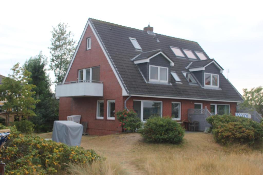 una gran casa roja con techo negro en Haus Seesand Wittdün, en Wittdün