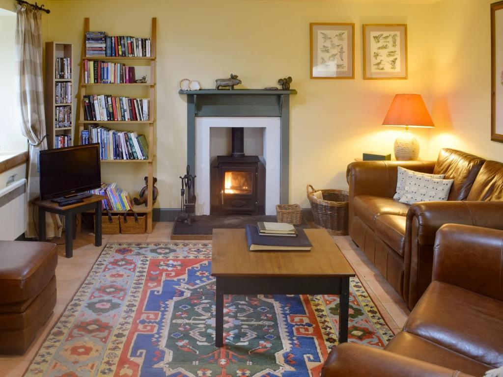 a living room with a couch and a fireplace at But n Ben in Lochdon