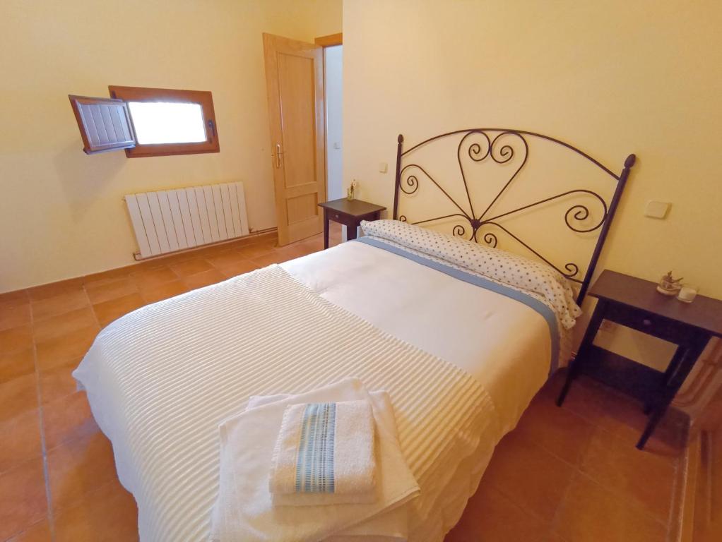 1 dormitorio con 1 cama blanca grande y 2 toallas en El Rincón del Sanabrés, Hermana Menor, petfriendly, en Rascafría