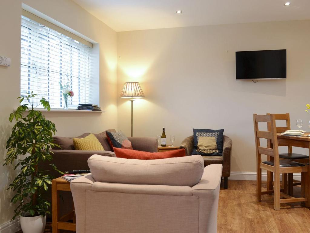 a living room with a couch and a tv at Croft Cottage 2 - Uk10588 in Stillington