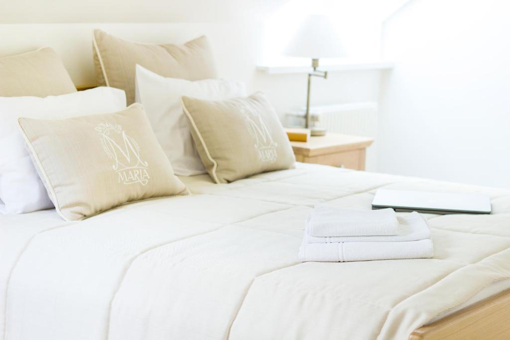 Domus Maria — A white bed with white pillows and a book on it