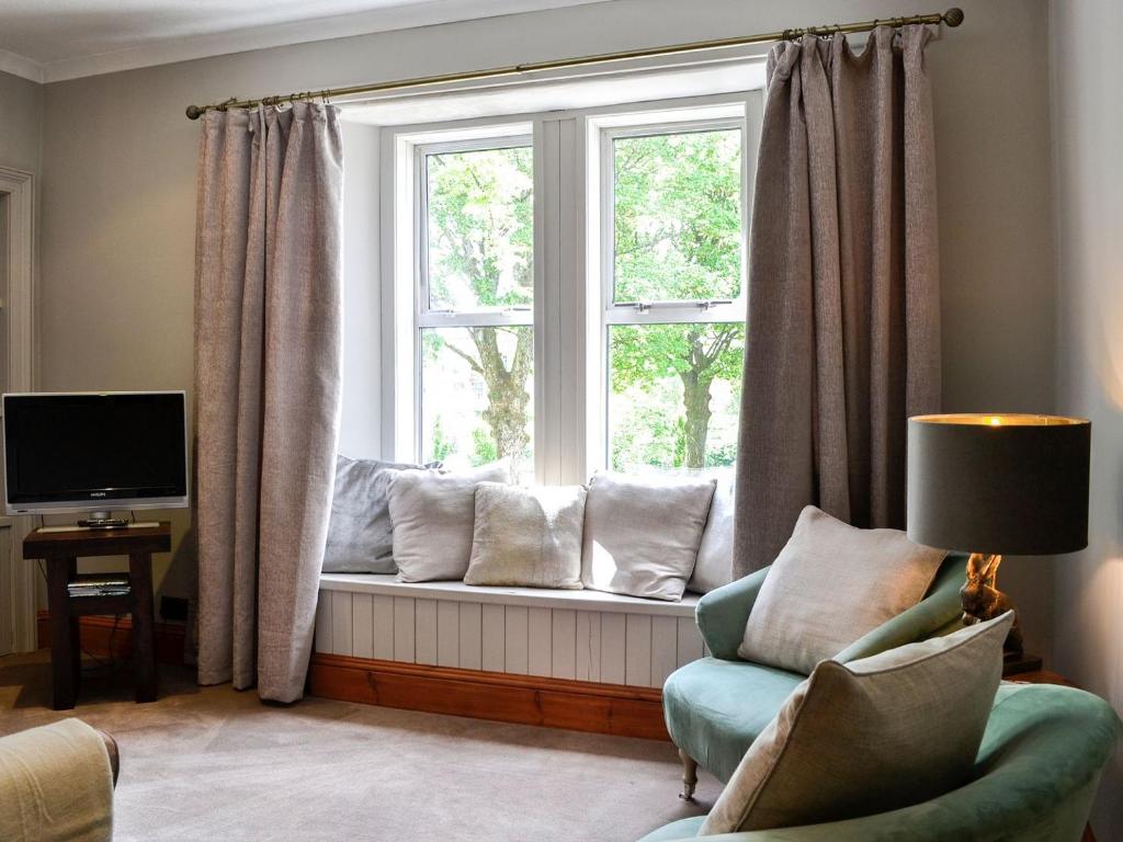 a living room with a window with a couch and a chair at River View in Dumfries