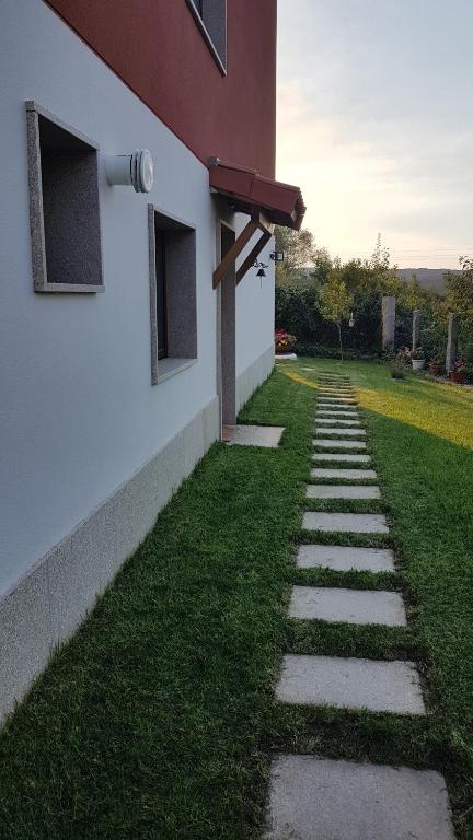 una pasarela junto a un edificio con un patio de césped en Lar do solpor, en Allariz