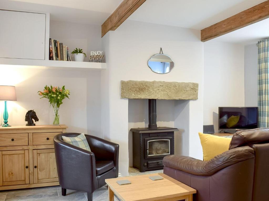 a living room with a couch and a wood stove at Weavers Cottage in Bingley