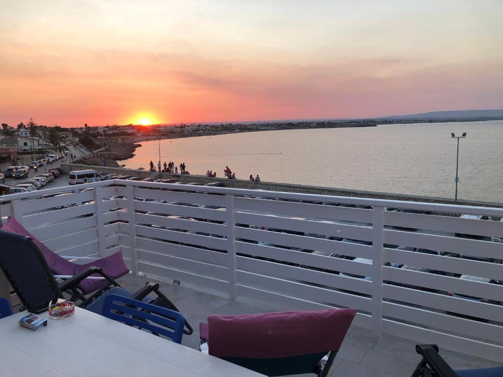 a balcony with a view of the water and the sunset at Sea House in Marzamemi