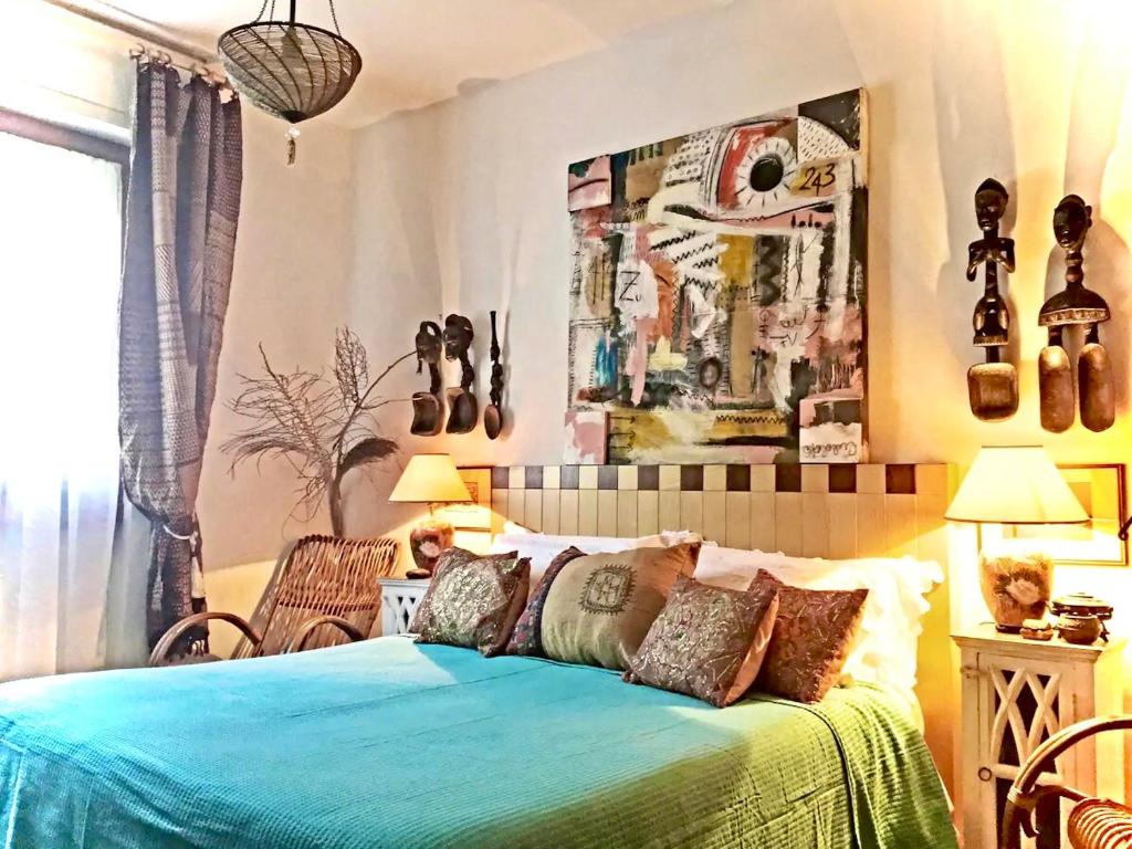 a bedroom with a bed with a blue blanket at La Rosa del Deserto, Versilia in Marina di Massa