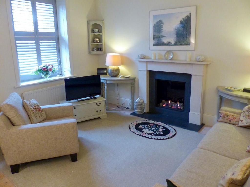 a living room with a couch and a fireplace at Chareside Cottage in Corbridge