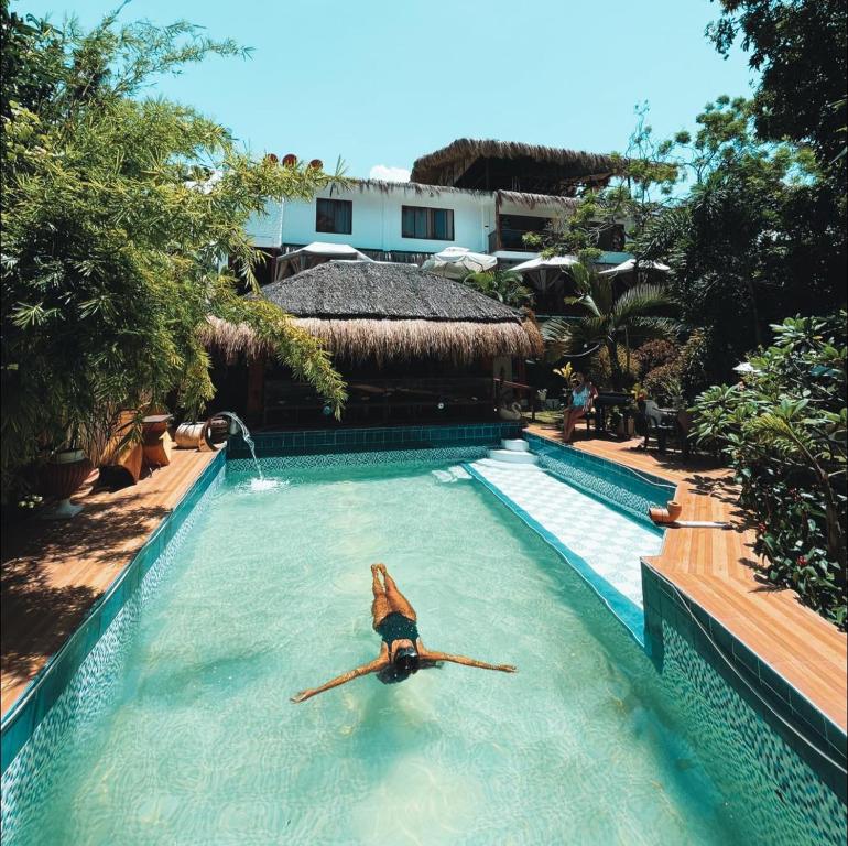 una donna in una piscina in un resort di GIARDINO ROMANTICO a Dumaguete