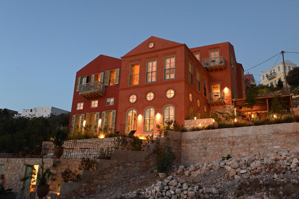 a large red brick building with lights on at Casa Mediterraneo Hotel in Meyisti