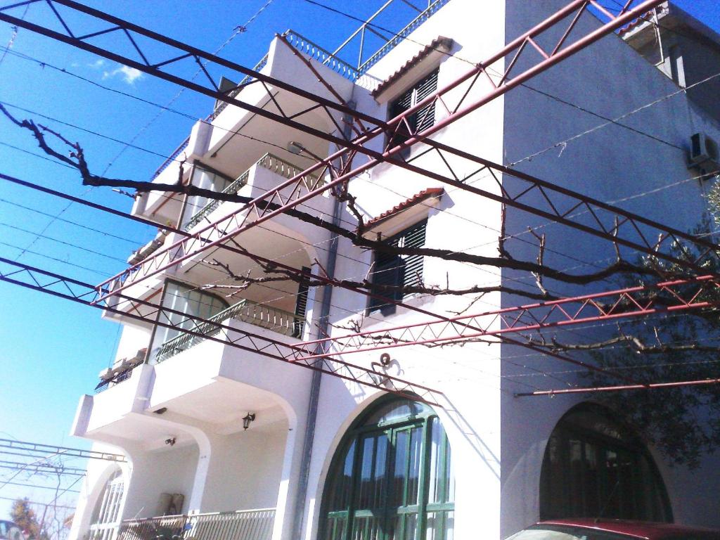 a white building with lots of wires in front of it at Hoxha rooms in Ulcinj