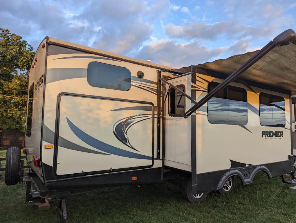 a rv parked in the grass with its door open at American Rv - Dog friendly - Peaceful location in Sutton on Sea