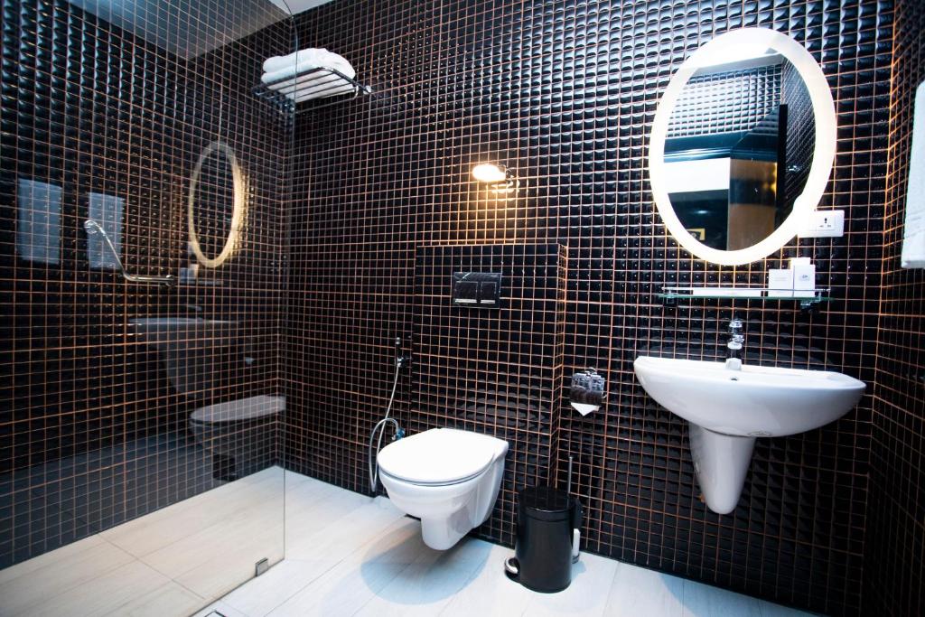 a bathroom with a toilet and a sink and a mirror at Hotel Philosophy in Amman