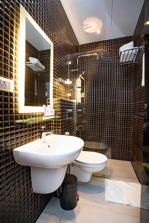 a bathroom with a sink and a toilet and a mirror at Hotel Philosophy in Amman