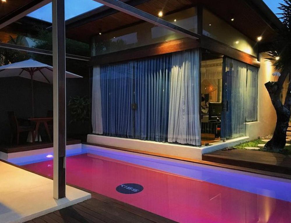 une maison avec une piscine la nuit dans l'établissement Kiss Bali Villas, à Seminyak