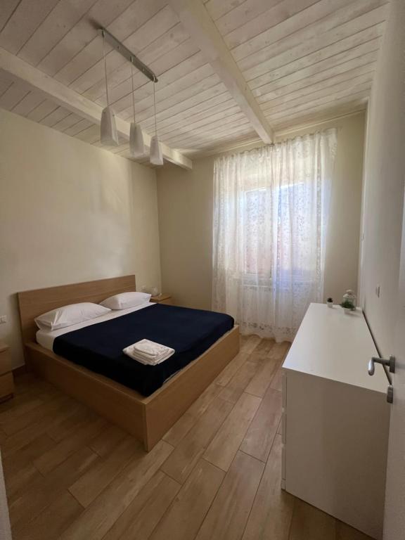 Un dormitorio con una cama grande y una ventana en Sea apartments, en Terracina