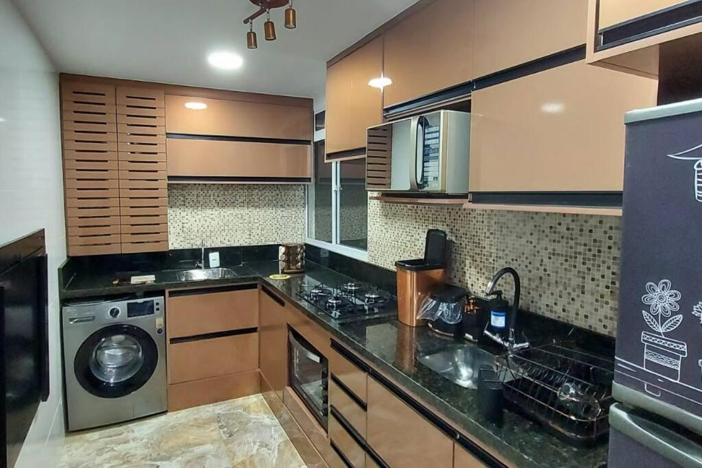 a kitchen with a washer and a washing machine at Apartamento aconchegante com ar condicionado de 22 a 8h in Rio de Janeiro