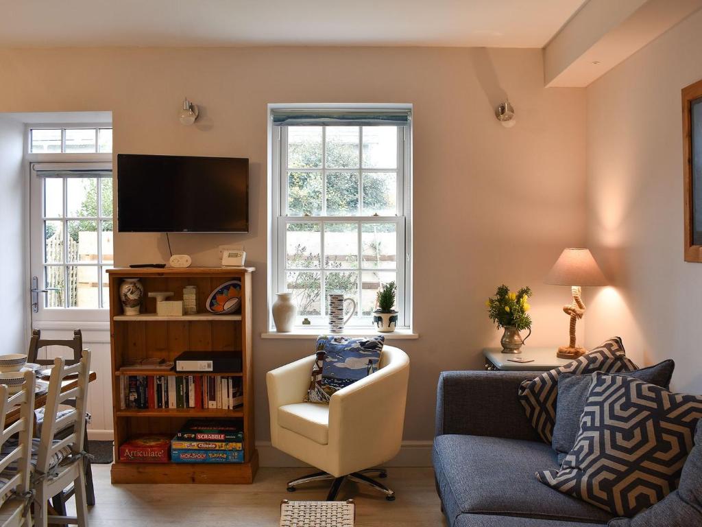a living room with a couch and a tv at Princessa Cottage in Bembridge