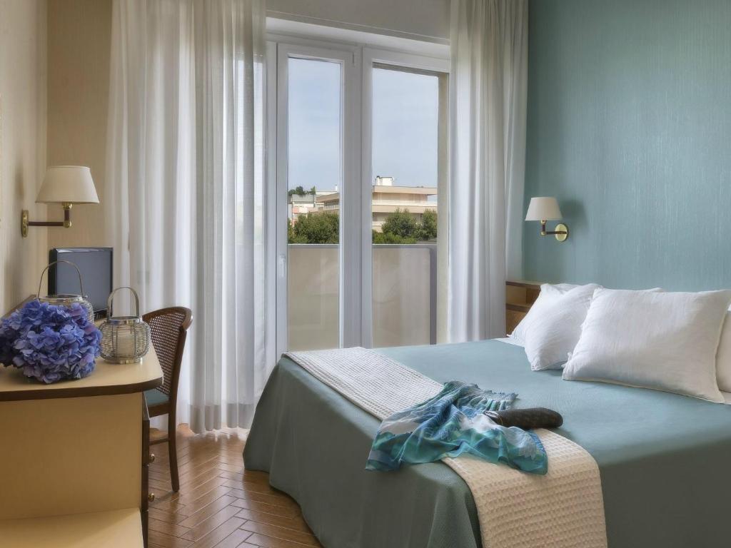 a hotel room with a bed with a window at Parioli Hotel Rimini in Rimini