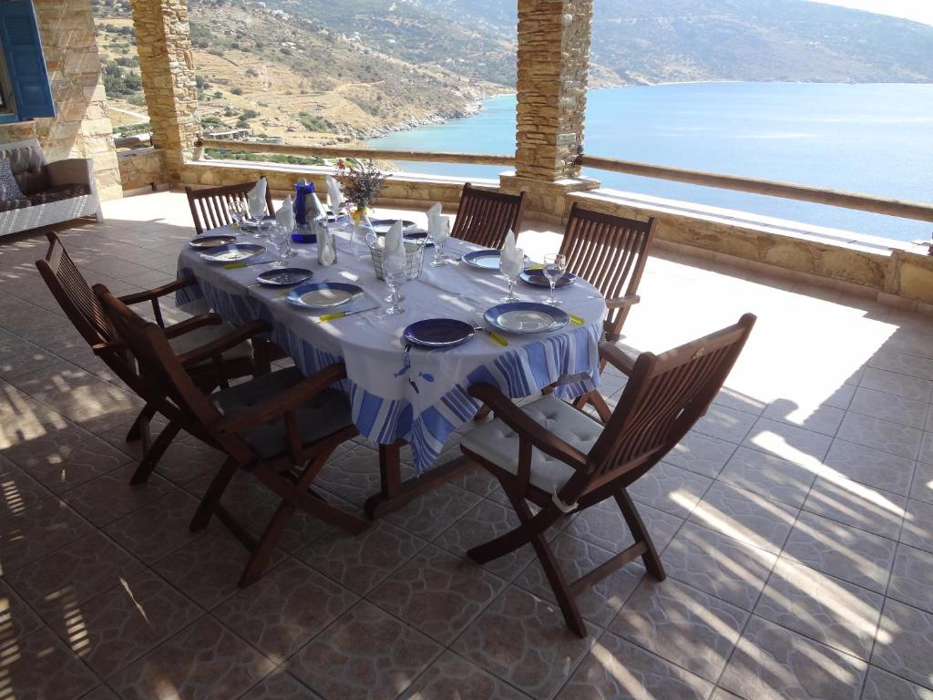 einen Esstisch mit Stühlen und Meerblick in der Unterkunft Luxurious Villa with Private Beach in Apróvaton
