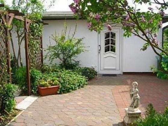a garden with a statue in front of a house at Ferienhaus in Kühlungsborn in Kühlungsborn