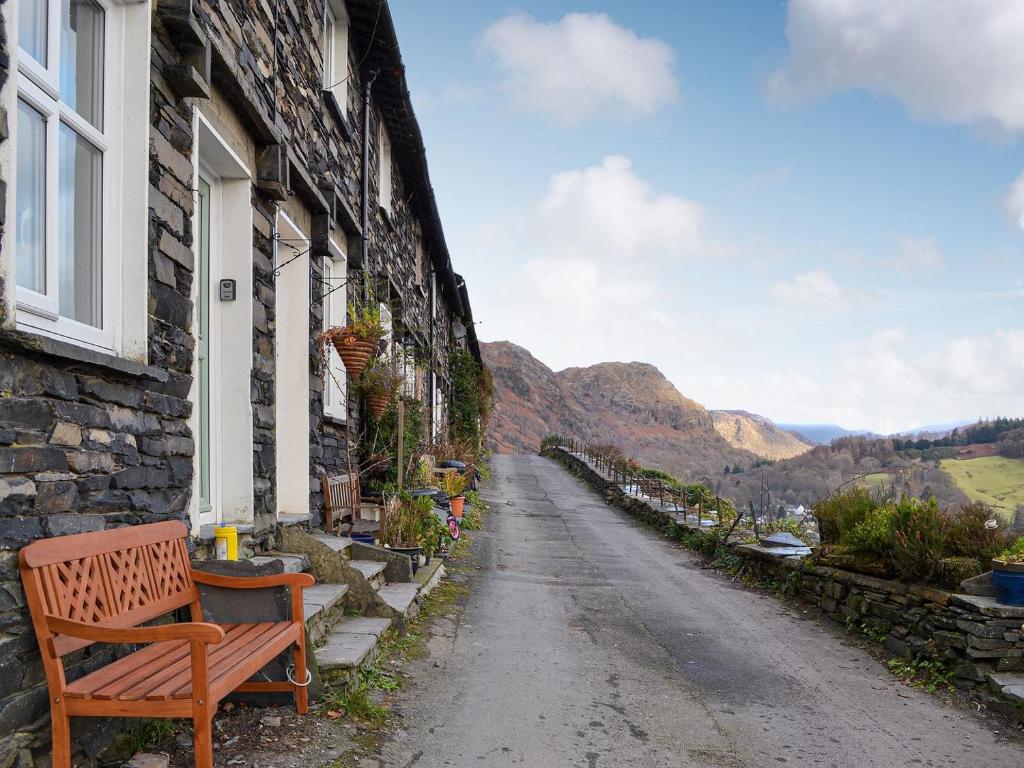 a bench sitting outside of a building on a street at Coniston Cottage in Coniston