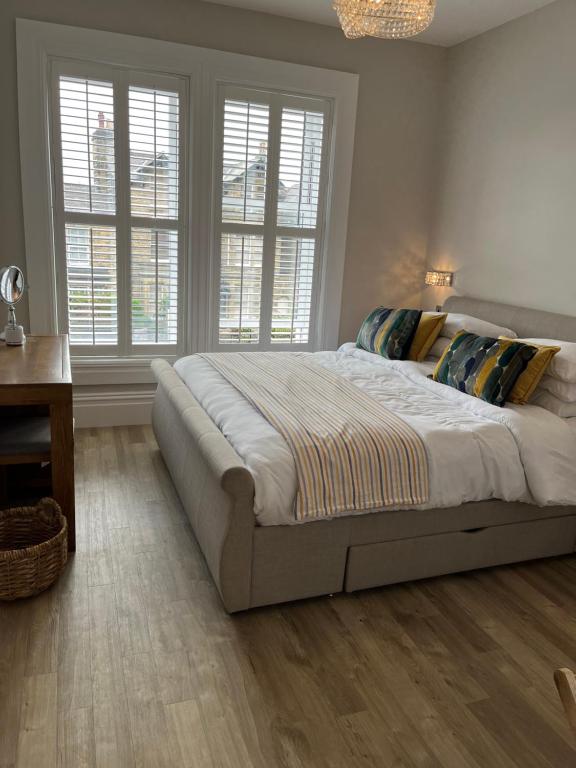 a bedroom with a bed and a desk and windows at Kings Apartment, 83 Kings Road in Harrogate