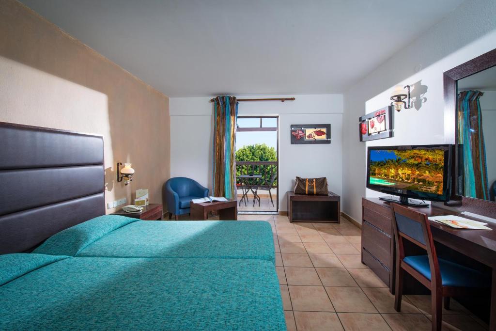 a bedroom with a bed and a flat screen tv at Hersonissos Maris in Hersonissos