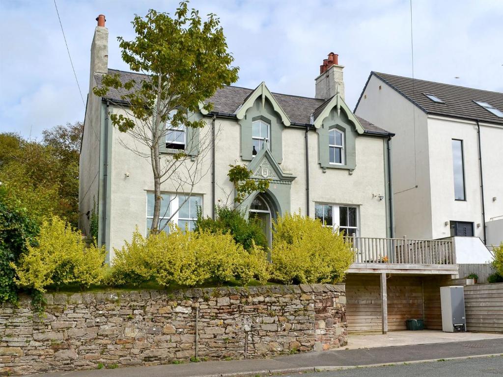 a large white house with a stone wall at Kingswood in Whitehaven