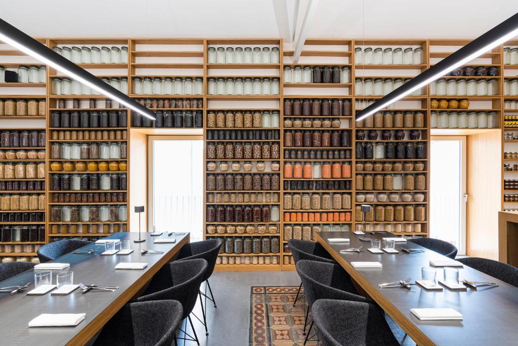 a row of tables in a library with books at Habitat in Catania