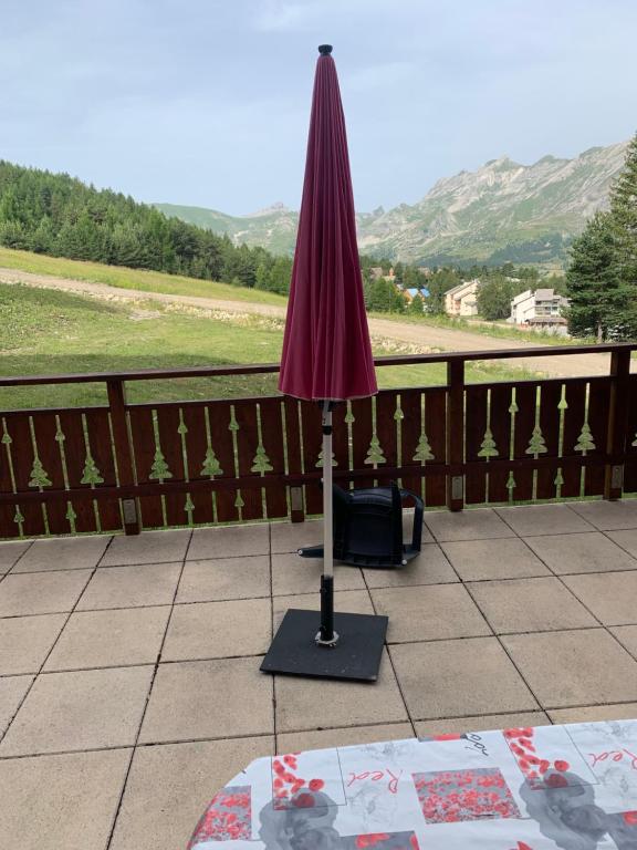 a purple umbrella sitting on top of a patio at l'appart accès direct sur les pistes in Le Dévoluy