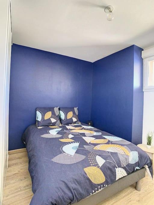 a blue bedroom with a bed with a blue wall at GRAND APPART TERRASSE PARKING DESIGN in Amiens