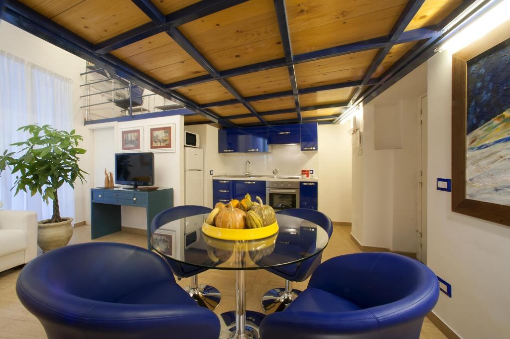 ナポリにあるCasa Vittoriaのダイニングルーム(ガラステーブル、青い椅子付)