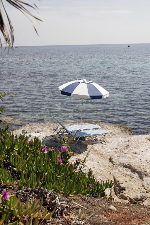 a blue and white umbrella sitting on a beach at Hersonissos Maris in Hersonissos