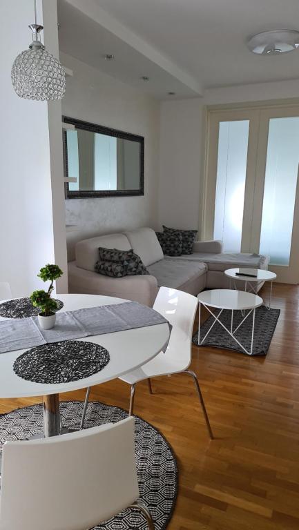 a living room with a couch and tables and chairs at Belville City apartment in Belgrade