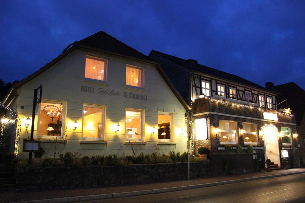 un edificio blanco con ventanas iluminadas por la noche en Hotel Garni Zur Linde en Hitzacker