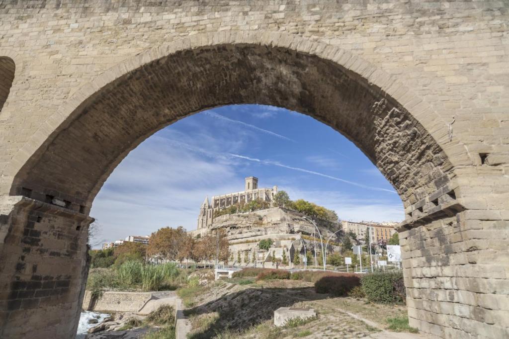 - une vue sur un château à travers une arche en pierre dans l'établissement Hospedaje24 - 3, à Manresa