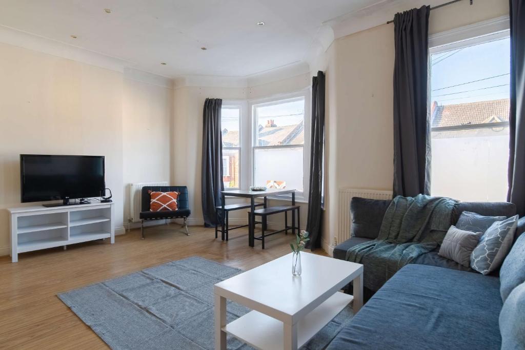 a living room with a couch and a table at Two Bedroom Apartment in Tooting in London