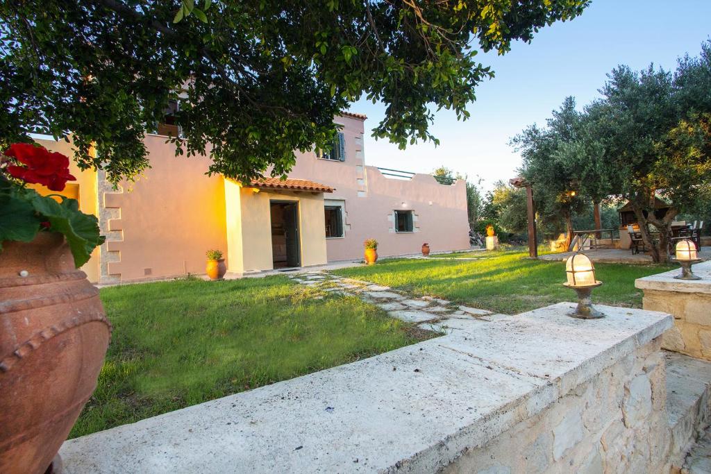 a yard with a house and a vase with a fire hydrant at Villa Manoutsio in Episkopí- Rethimno