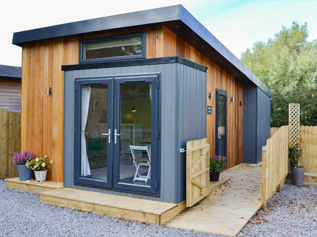 a tiny house with a dark blue exterior at Curlew in Westward