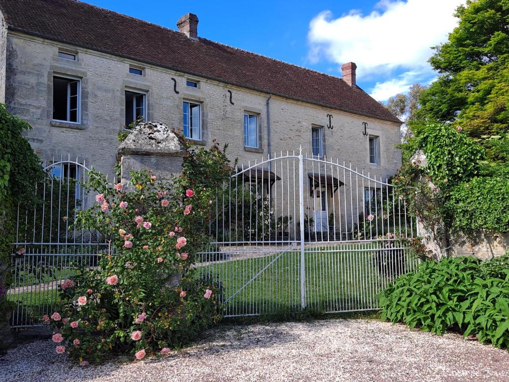 a gate in front of a house with pink roses at La Gentilhommière de Moulins 