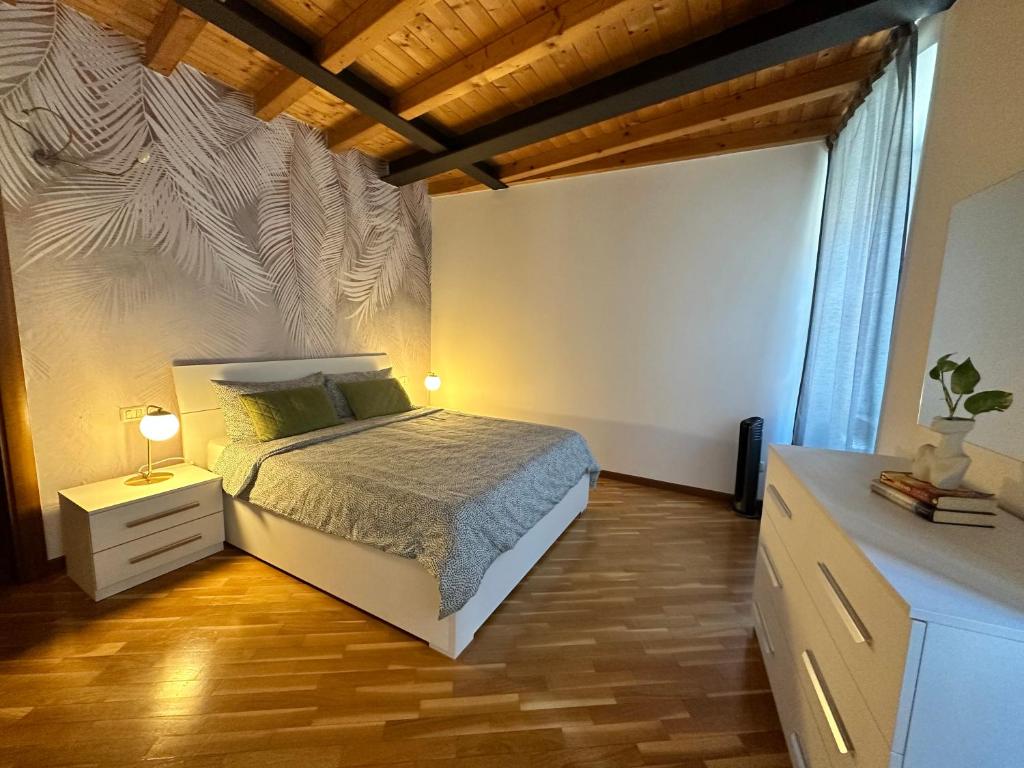a bedroom with a bed and a dresser with a night stand at Stella / Bergamo center in Bergamo