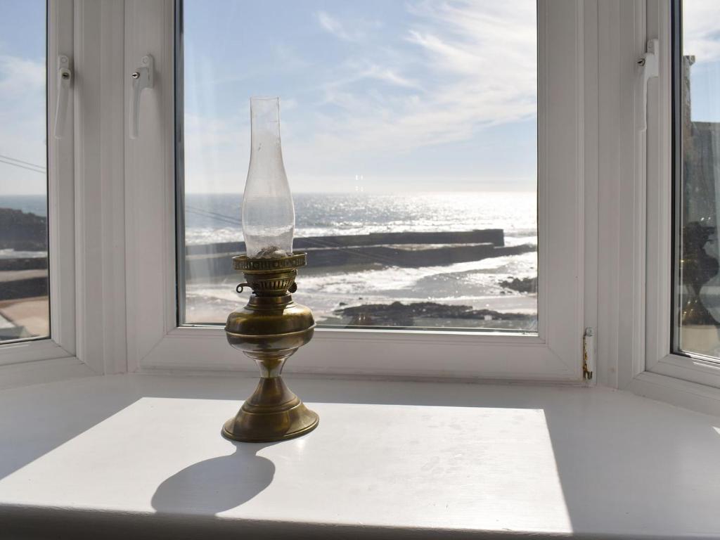 a vase sitting on a table in front of a window at Seaton Cottage in Collieston